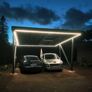 Ombrière photovoltaïque éclairée au crépuscule abritant deux véhicules